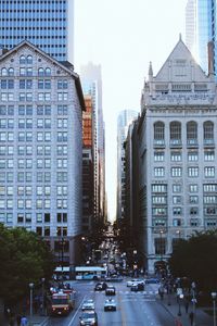 Cars on road in city against clear sky