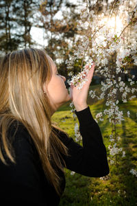 Beautiful woman smelling flowers