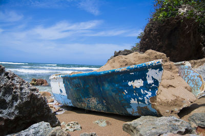 Old broken boat wash up on shore at the beach