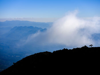 Silhouette of mountain against cloudy sky