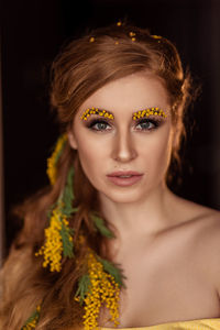 Portrait of a young woman in yellow mimosa flowers