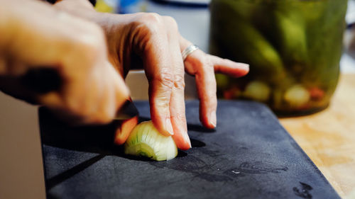 Cropped hands chopping onion