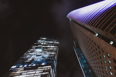 Low angle view of illuminated buildings against sky at night