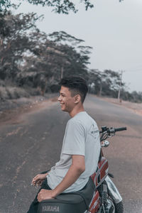 Side view of man sitting on road