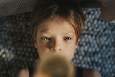 Directly above shot of boy lying in bedroom at home