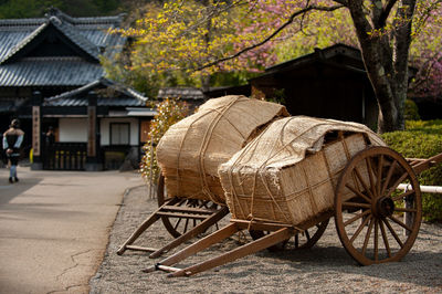 Carts on land against trees and buildings in city