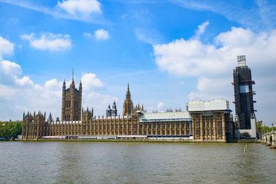 Panoramic view of buildings by river against sky in city