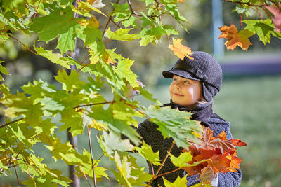 Boy looking away on plant leaves