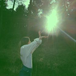 Woman in sunlight falling on field