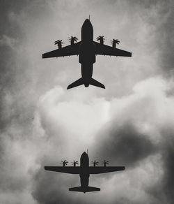 Low angle view of silhouette airplane against sky