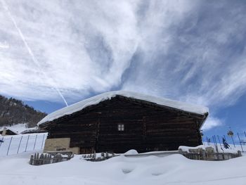 Snow covered houses and buildings against sky