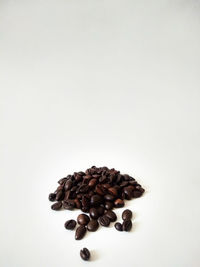 High angle view of coffee beans against white background