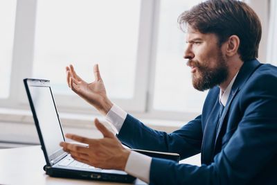 Young woman using mobile phone while sitting in office