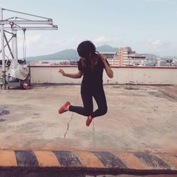 Full length of woman jumping against sky