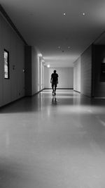 Woman walking in illuminated corridor