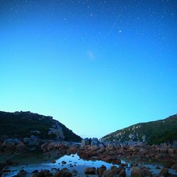 Calm lake against clear blue sky