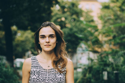 Close-up portrait of young woman with brown hair in city