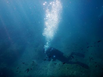 Person swimming underwater in sea