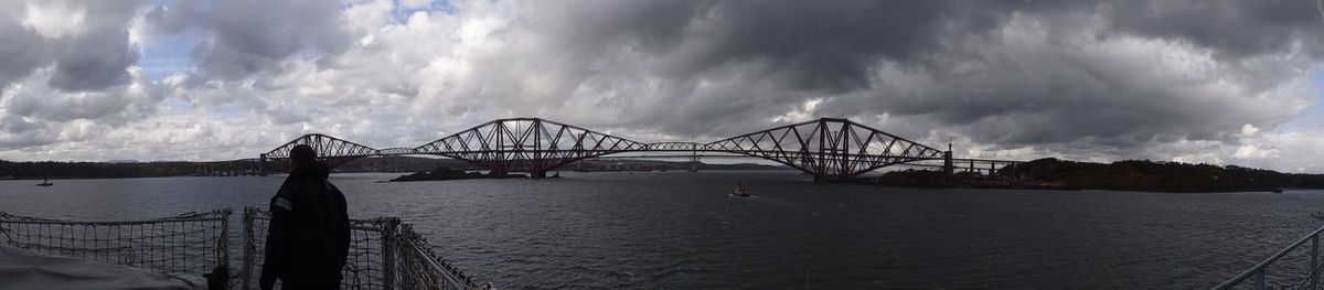 Bridge over river against cloudy sky