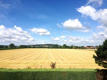 Scenic view of field against cloudy sky