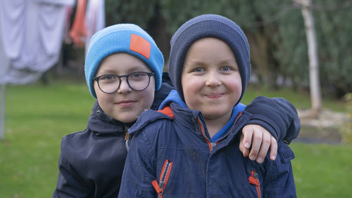 Portrait of smiling young woman standing against trees