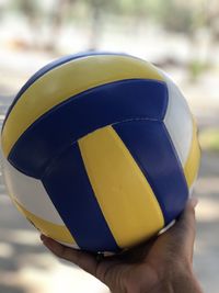 Close-up of hand holding volleyball ball