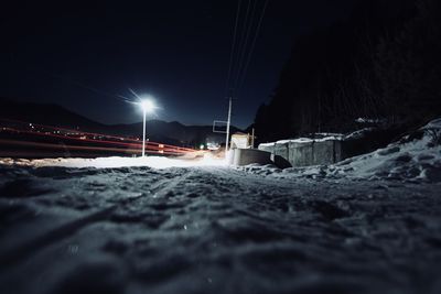 Snow covered road against sky at night