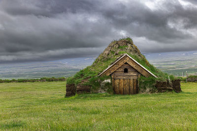 Built structure on field against sky