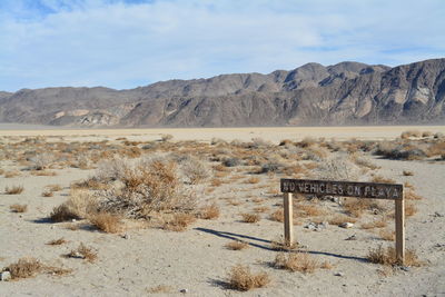 Information sign on desert against sky - race track playa death valley national park