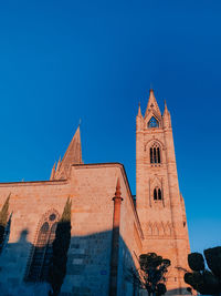 Low angle view of clock tower against blue sky