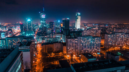 Illuminated cityscape against sky at night