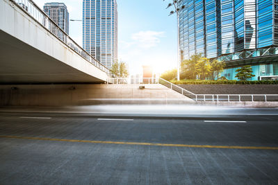 Empty road amidst buildings in city against sky