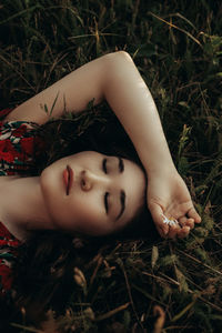 High angle portrait of woman lying on field