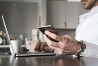 Midsection of man using mobile phone