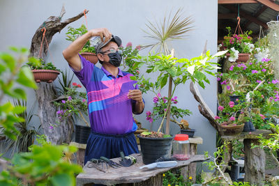 Woman standing by potted plants