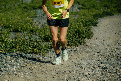 Low section of man running on field