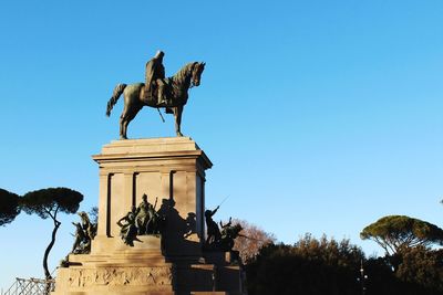 Low angle view of statue against clear blue sky