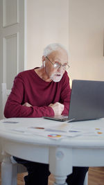 Senior man using laptop in rehab center