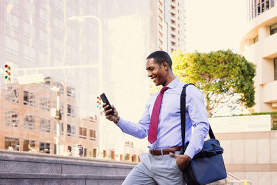 Portrait of young man standing against building