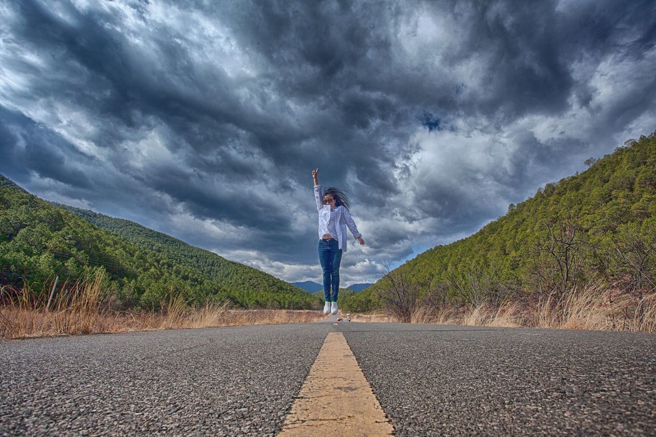 sky, cloud - sky, the way forward, cloudy, cloud, road, one person, weather, diminishing perspective, vanishing point, overcast, tranquility, nature, tranquil scene, storm cloud, rear view, full length, grass, street, day