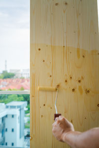 Close-up of hand holding yellow wood