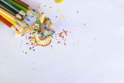 High angle view of multi colored pencils on white background