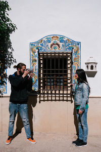 Boy taking pictures of a woman on a sunny day