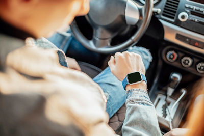 Smart watch on the hand of car driver, close up. transport, business trip, technology, time concept