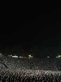 Crowd at music concert against sky at night