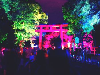 People on illuminated building at night