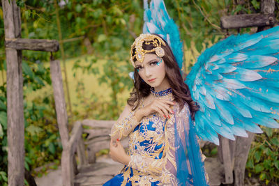 Portrait of young woman standing in forest