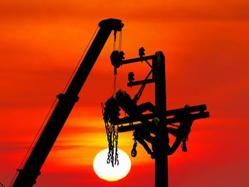 Low angle view of silhouette crane against sky during sunset