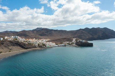 Scenic view of sea and mountains against sky