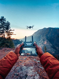 Airplane flying over mountains against clear sky